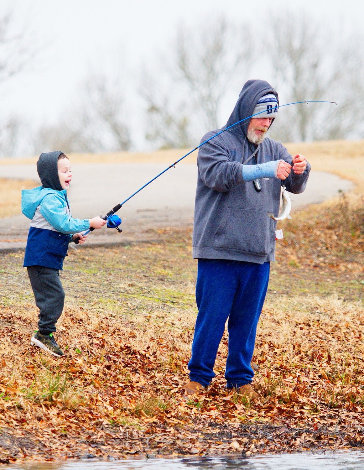 John Langford assists excited angler Noble Langford with his first catch of the day. [find further fun fishing photos]
